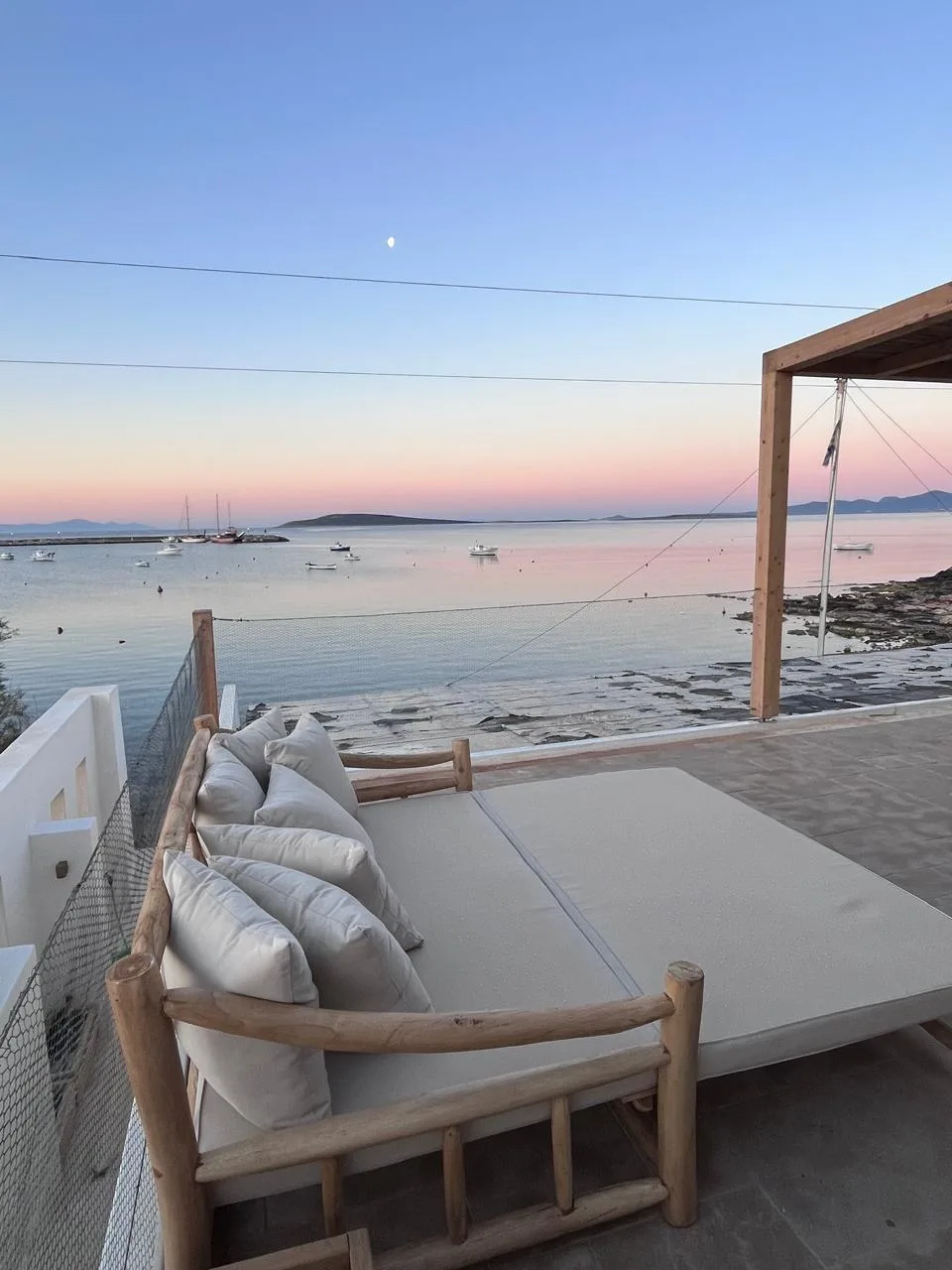 Daybed at sunset with rising moon over the bay