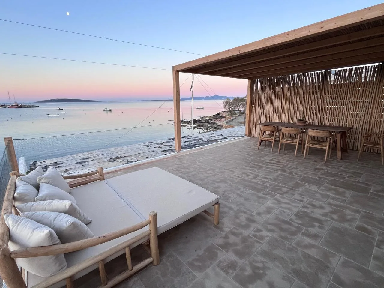 Terrace daybed and dining area at golden hour