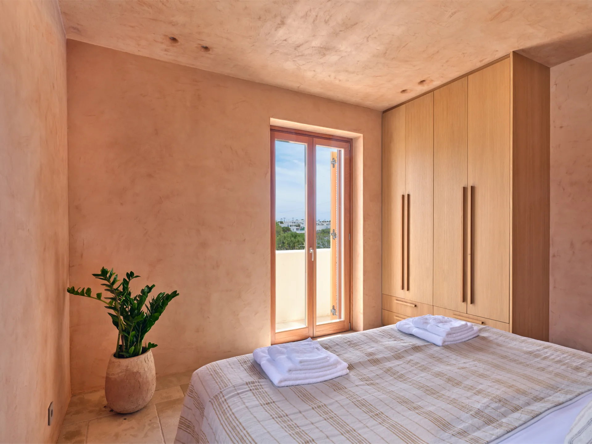 Bedroom bed and wardrobes beside the balcony